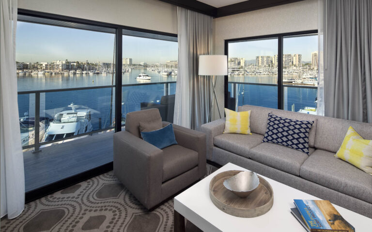 Hotel suite living area with a marina-view balcony