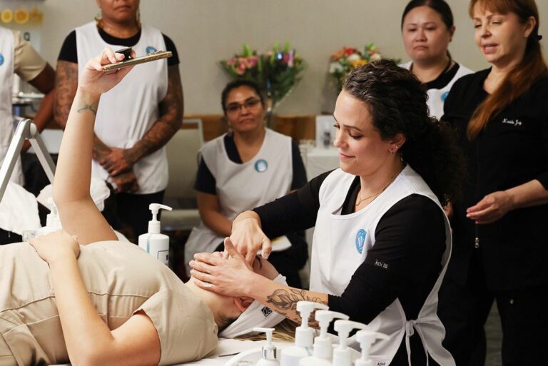 Estheticians gathered around a hands-on facial demonstration