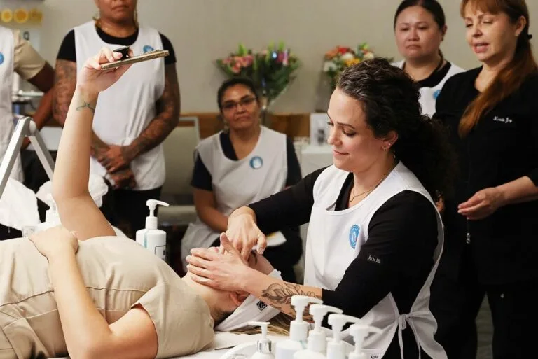 Estheticians gathered around a hands-on facial demonstration